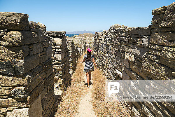 Griechenland  Mykonos  Delos  Frau  die an den alten Häusern der archäologischen Stätte spazieren geht.