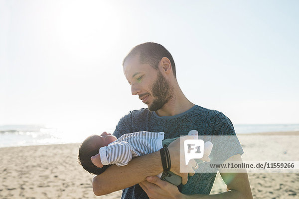 Father with his newborn baby girl on the beach