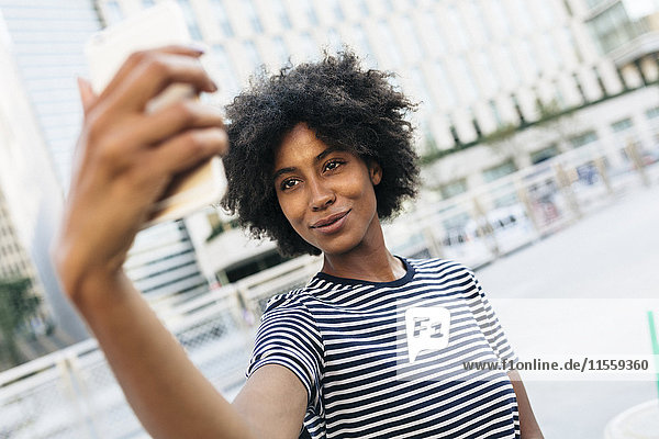 Portrait of smiling young woman taking selfie with smartphone
