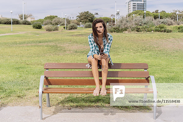 Junge Frau auf der Bank am Strand sitzend