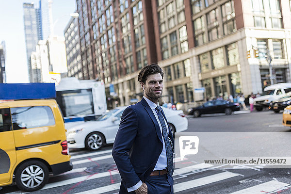 Geschäftsmann in den Straßen von Manhattan mit gelbem Taxi im Hintergrund