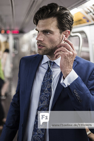 Geschäftsmann in der U-Bahn mit Smartphone