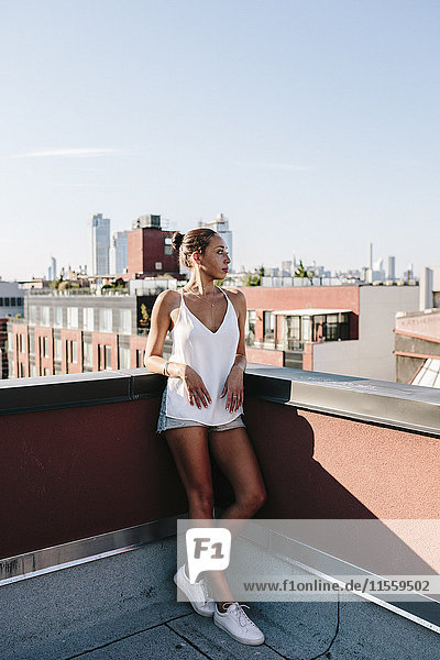 Entspannte Frau steht auf dem Dach in Brooklyn
