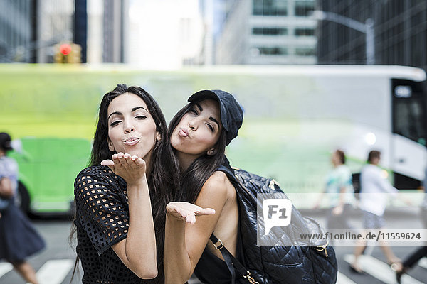 USA  New York City  zwei Zwillingsschwestern beim Küssen in Manhattan