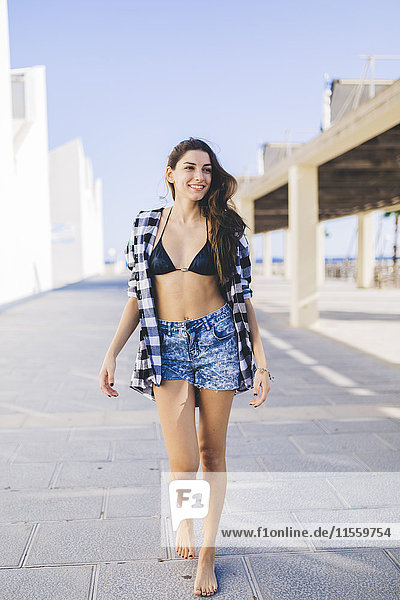 Young pretty woman wearing beach wear  walking in street