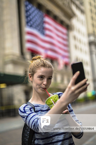USA  New York City  woman taking selfie in front of New York Stock Exchange