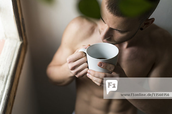 Attraktive junge Amnesie mit Sechserpackung Kaffee trinken