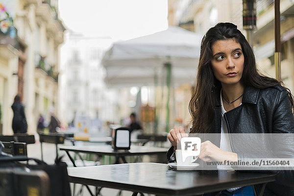 Junge Frau in einem Straßencafé