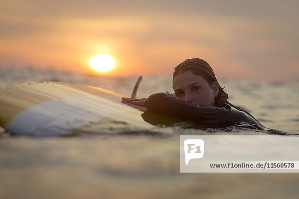 Indonesien  Bali  Portrait einer Surferin im Meer bei Sonnenuntergang