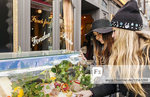 Frankreich  Paris  zwei weibliche Touristen  die in den Eingang eines Restaurants schauen.