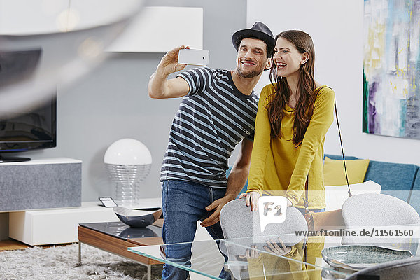 Paar im Möbelhaus mit Blick auf den Esstisch  Fotografieren mit Smartphone