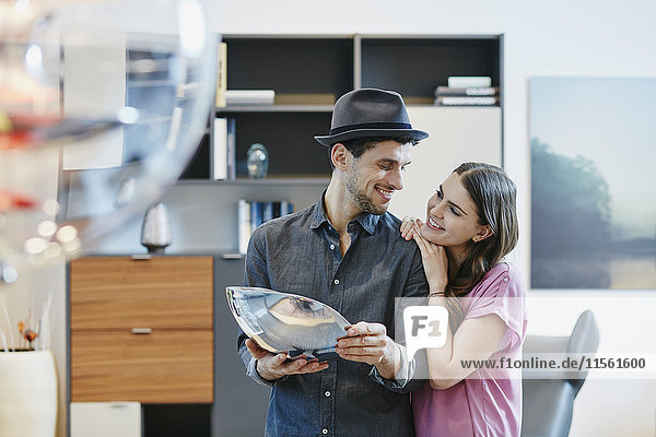 Couple in furniture store holding accessories