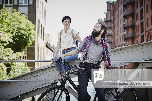 Germany  Hamburg  couple with electric bicycle on a bridge