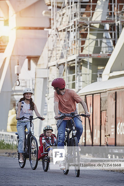 Germany  Hamburg  family riding e-bikes at the harbor