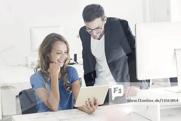 Young man and woman working together in office