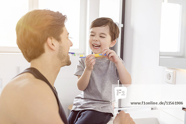 Glücklicher Vater und Sohn beim Zähneputzen im Bad