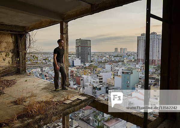 Vietnam Ho-Chi-Minh-Stadt Mann steht in Ruine eines Wolkenkratzers