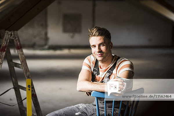 Young man sitting on construction site of his new home