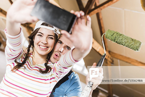Young couple renovating their new home  taking smart phone selfies