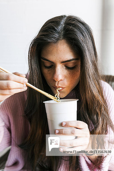 Junge Frau isst chinesische Nudeln