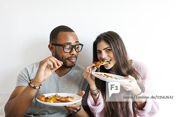 Junges Paar zu Hause beim Pizzaessen