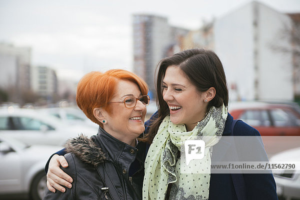 Happy adult daughter with mother in the city