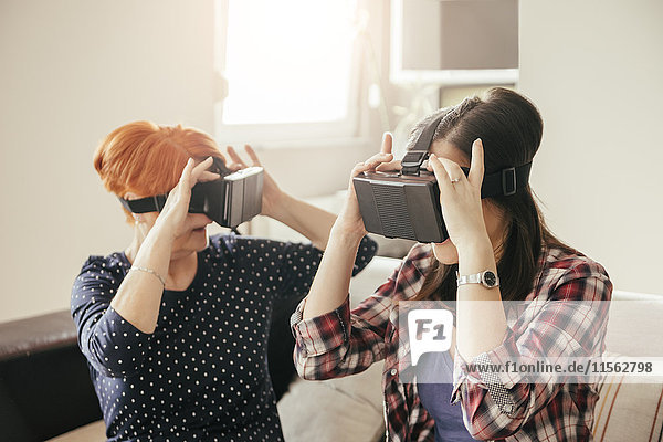 Erwachsene Tochter mit Mutter zu Hause mit VR-Brille