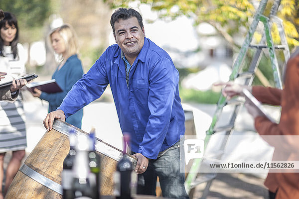 Wine barrel worker with saleswoman outdoors