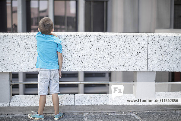 Junge auf der Brücke stehend  Blick auf das Geländer  Rückansicht