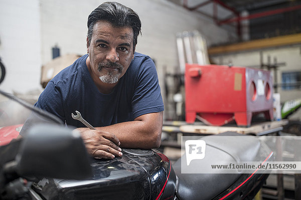 Porträt eines selbstbewussten Mechanikers in der Motorradwerkstatt