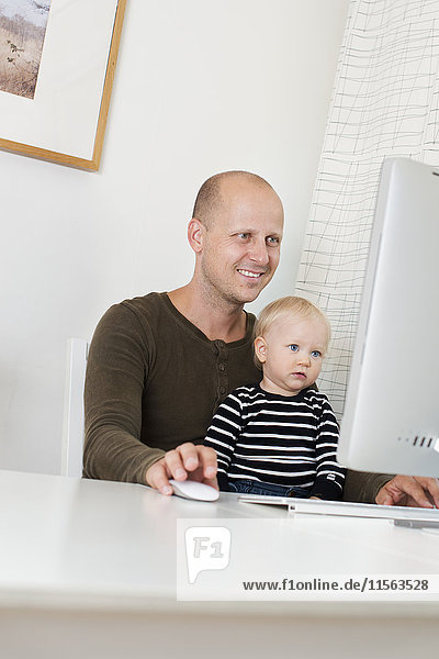 Schweden  Vater mit Sohn (12-17 Monate) am Computer