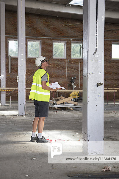 Schweden Mann steht auf der Baustelle und hält Papiere in der Hand