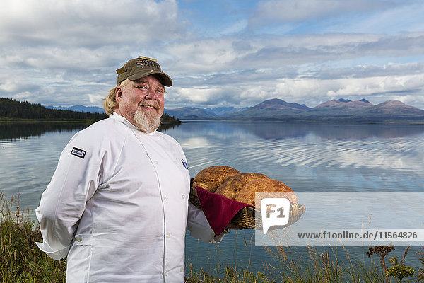 Matt Spence  Küchenchef der Tikchik Narrows Lodge  hält einen Korb mit frisch gebackenem Brot am Ufer des Tikchik Lake  Wood-Tikchik State Park  Südwest-Alaska  USA