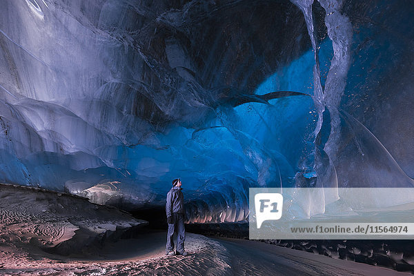 Ein Mann steht in einem Eistunnel unter dem Black Rapids Glacier  Alaska Range  Inner-Alaska  USA