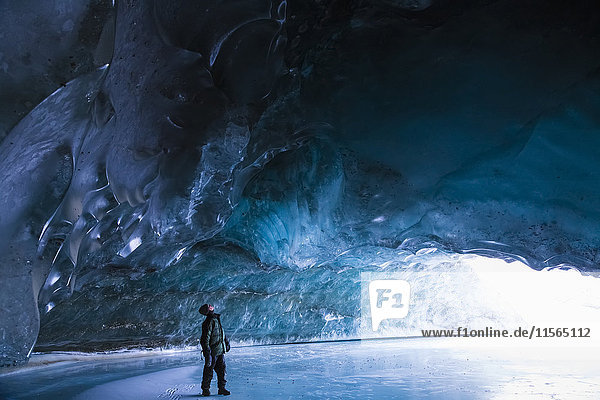 Ein Mann untersucht an einem kalten Januartag das Eis in einer Höhle des Canwell-Gletschers in der Alaska Range.