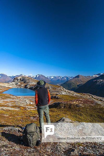 'A man hiking near an unnamed lake near the Harding Icefield Trail in Kenai Fjords National Park on a summer day  South-central Alaska; Alaska  United States of America'