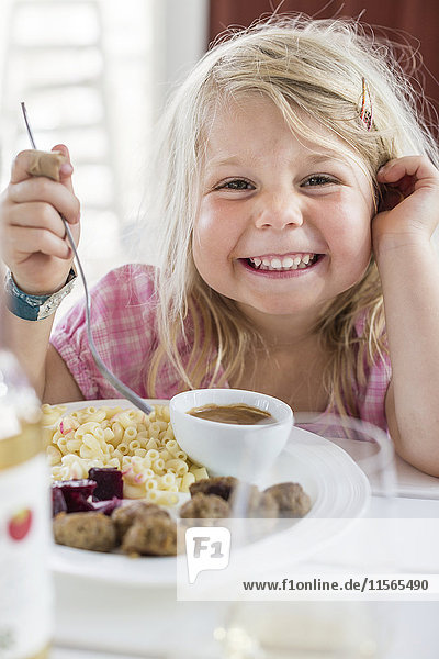 Porträt eines lächelnden Mädchens beim Essen