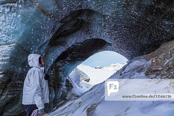 Eine junge Frau beobachtet das freigelegte Eis des Castner-Gletschers in der Alaska Range im Winter; Alaska  Vereinigte Staaten von Amerika'.