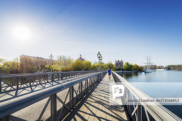 Schweden Stockholm Skeppsholmen Junger Mann läuft auf Brücke