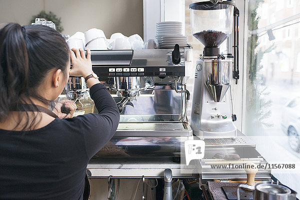 Woman preparing coffee in cafe