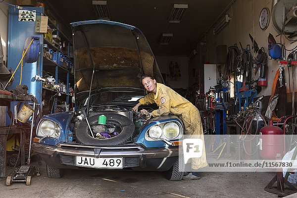 Woman mechanic repairing vintage car