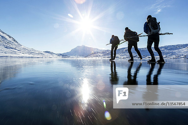 Three people skiing on frozen lake