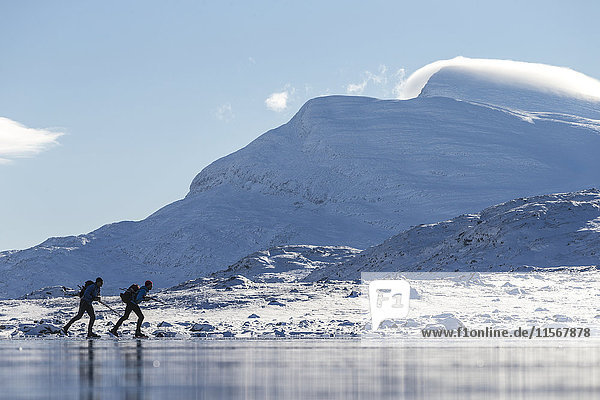 People skiing on frozen lake