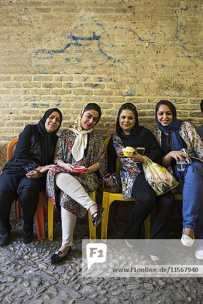 Junge Frauen genießen das gefrorene Dessert Fallodeh auf dem Vakil-Basar; Shiraz  Provinz Fars  Iran'.