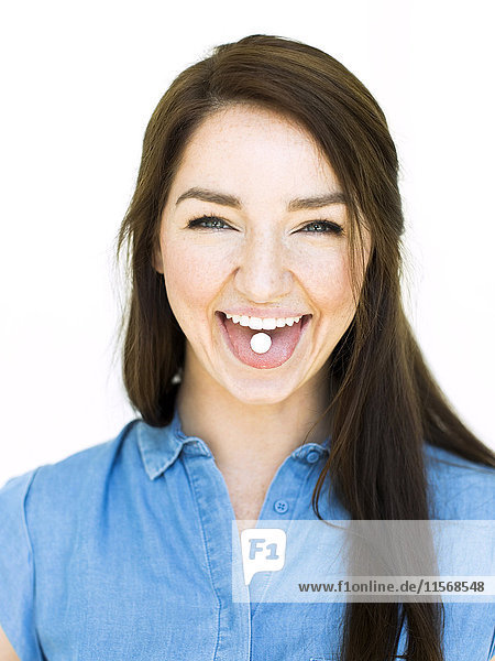 Frau zeigt Minze auf der Zunge