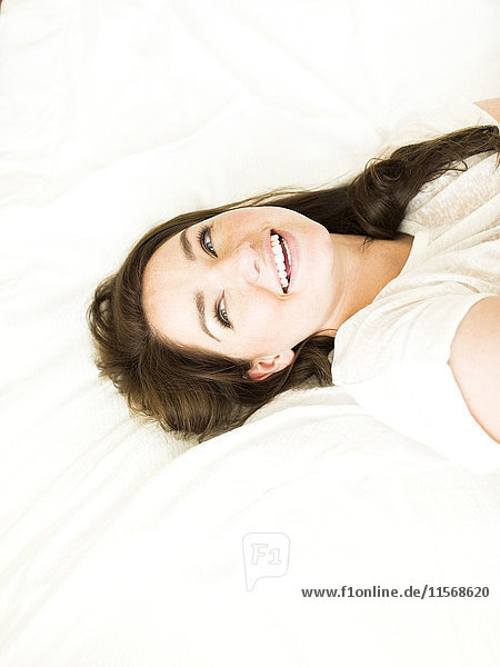 Woman lying on bed and smiling