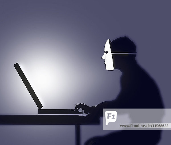 Mann mit einer Maske benutzt einen Computer