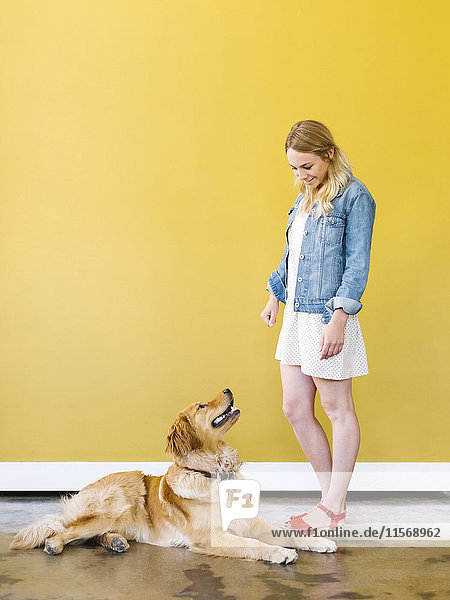 Young woman playing with golden retriever