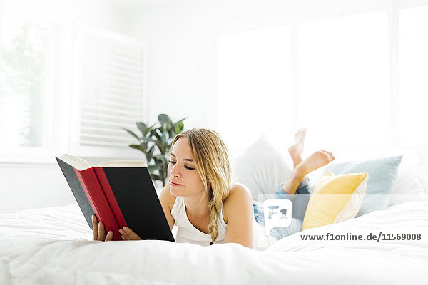 Woman reading book in bedroom