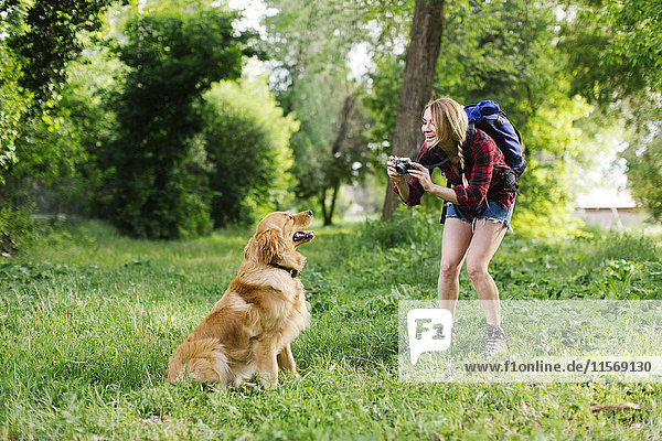 Frau fotografiert Hund auf Wandertour